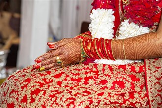 Traditional bridal jewelry and henna decoration on the hands of the bride during a religious ceremony at a Hindu wedding