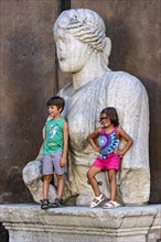Children posing at the ancient Roman colossal statue Madama Lucrezia