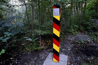 Border column with GDR coat of arms in the forest