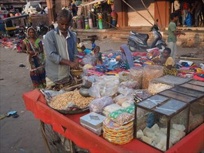 Vendor offering snacks at market stall