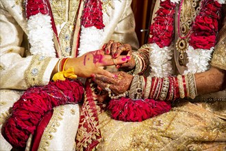 Indian bride passing wedding ring on her groom's finger on her wedding ceremony