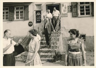 Southern Germany in 1959: Participants of a company outing leave a pub. Stairs to the entrance