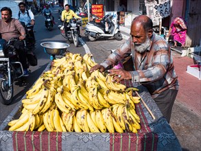 Vendor offering bananas at market stall