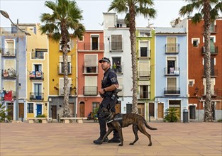 Policeman with dog in front of Colorful beachfront houses