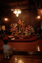 Darkened worship room with monk statue in Buddhist monastery Wat Chalong
