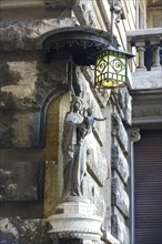 Statue of Madonna and Child on the facade of the Palazzi degli Ambasciatori Embassy palaces with archway to the Quartiere Coppede