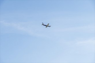 Landing small passenger airplane on blue sky