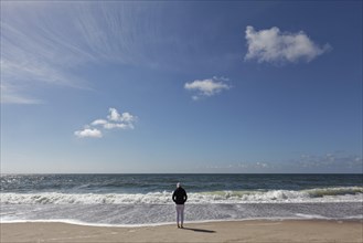 Single person with hoodie standing on the beach