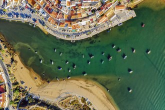 Aerial cityscape of white washed Ferragudo by Arade River