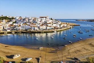Aerial cityscape of white washed Ferragudo by Arade River