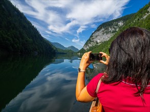 Tourist photographing Lake Toplitz from a traditional barge