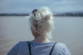 Blonde girl with tied up hair seen from behind