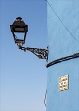 Close-up of streetlight and blue wall