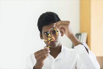 Student holding a model in his study