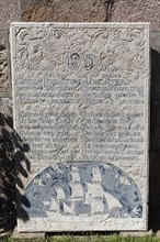 Historical grave slab with sailing ship and inscription