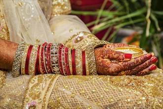 Traditional bridal jewelry and henna decoration on the hands of the bride during a religious ceremony at a Hindu wedding