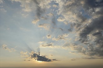 Morning sun hidden by cumulus clouds