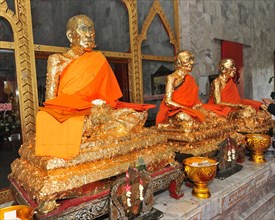 Statues of monks covered with gold leaf in Buddhist temple