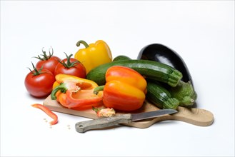 Ingredients for ratatouille on wooden board with knife