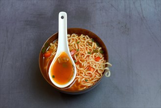Asian noodle soup in bowl with Asian spoon