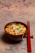 Asian noodle soup in bowl with chopsticks