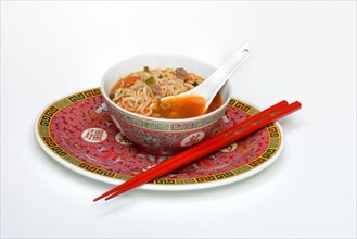 Asian noodle soup in bowl with Asian spoon and chopsticks