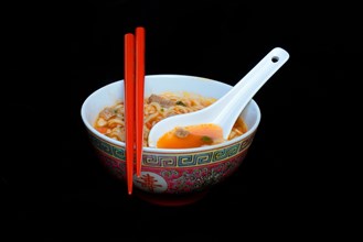Asian noodle soup in bowl with Asian spoon and chopsticks