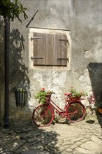 Red wheel standing in front of wall