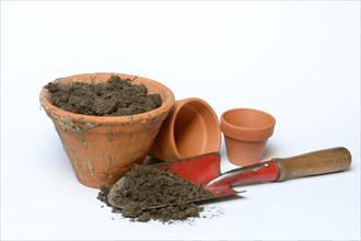 Clay pots with soil and garden shovel