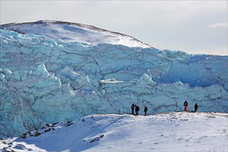 People in front of the break-off edge of the Russell Glacier