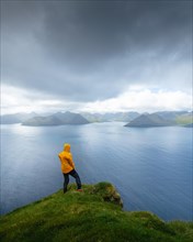Person looking at the sea and the island of Eysturoy