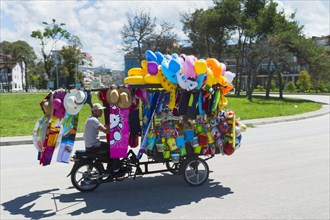 Beach vendor on tricycle with colorful balloons