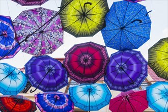 Colorful umbrellas hanging in the street