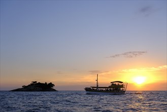 Tourist boat in the sea at sunset