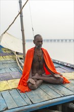 Sadhu with red scarf on boat on the Ganges