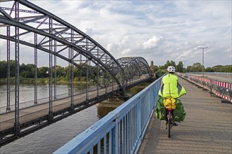 Woman riding her bicycle over bridge next to the Alte Harbruecker Elbbruecke