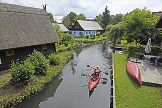 Tourists paddle through the village of Lehde