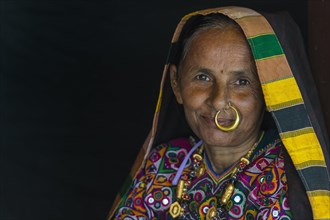 Elderly Ahir woman in traditional colorful cloth with a nose ring