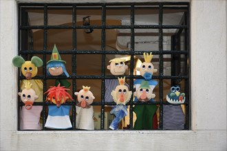 Hand puppets in barred window