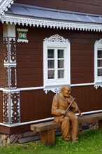 Wooden musician in front of house