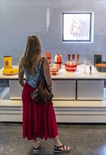 Young woman in the glass museum looking at hand-blown glass