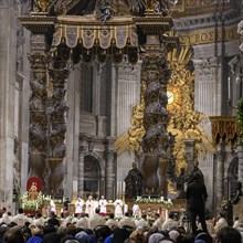 Pope with mitre prays during Saint Mass in St. Peter's Basilica in front of faithful Christians