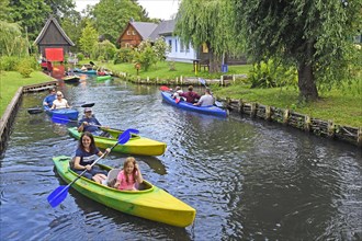 Tourists paddle through the village of Lehde