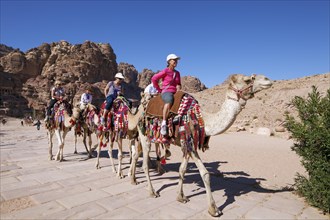 Tourists riding camels (Camel dromedarius) on Colonnade Street