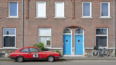 Street scene with red racing car and traditional Dutch bicycle