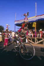 Folk dancer of Karakattam balancing on bicycle