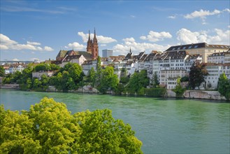 View of the Basel Cathedral in the middle of the old town of Basel with the turquoise Rhine River in the foreground