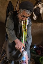 Sufi man preparing his marihuana pipe