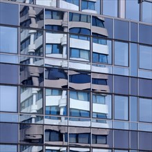 Savings bank tower reflected in the glass facade of GESCO AG