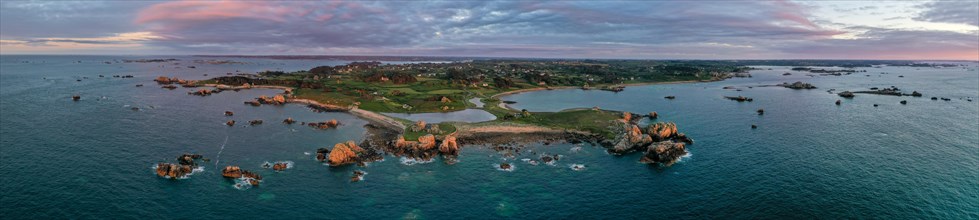 Panorama drone shot from the Atlantic Ocean onto the granite coast of Plougrescant with a view of the house between the rocks (Le gouffre de Plougrescant) at sunset